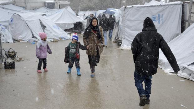 Varios refugiados caminan bajo la nieve en el campamento de refugiados de Moria