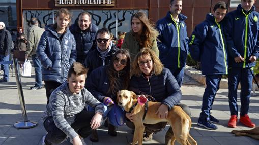 Imagen de una familia con su perro adoptado en el desfile