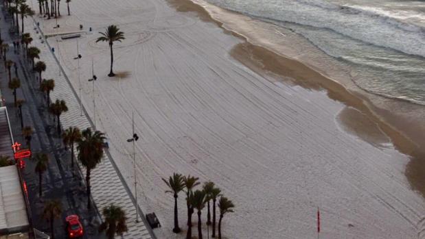 La playa de Benidorm con la arena cubierta casi por completo de granizado, este jueves