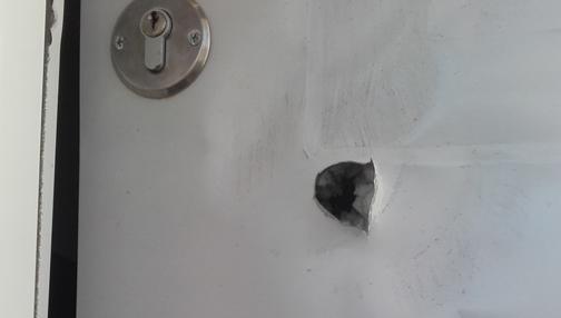 Detalle del impacto de bala en la puerta de la vivienda