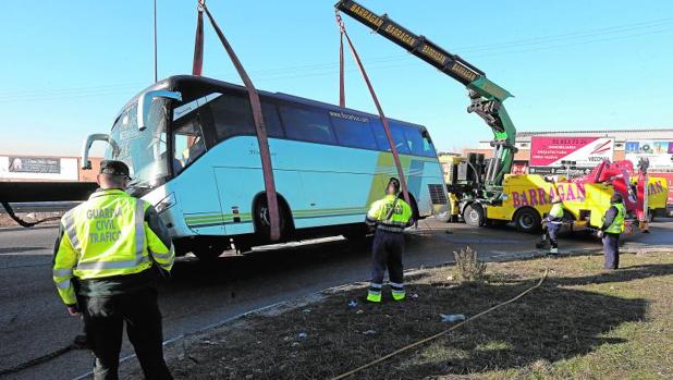 El bus, en el momento de ser levantado, tras el siniestro