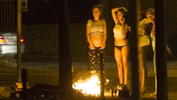 Un grupo de prostitutas se refugia del frío con una hoguera