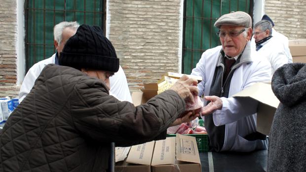 Cipriano, a la derecha, reparte comida en la sede de la ONG «Socorro de los pobres»'