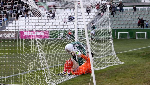 Un jugador del Toledo recoge el balón de la portería del Mensajero tras lograr Javi Gómez el segundo gol