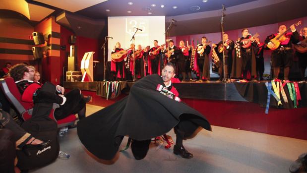 Un tuno danza al son de la música que toca un grupo en el escenario