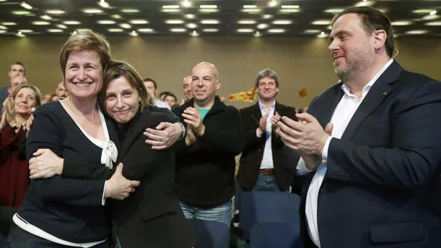 La presidenta del Parlament catalán , Carmen Forcadell, se abraza a la diputada Anna Simo en presencia de Junqueras