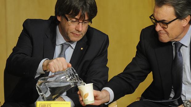 Carles Puigdemont, presidente de la Generalitat catalana, sirve agua a Artur Mas, en una imagen de archivo