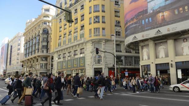 Cientos de turistas transitan por la Gran Vía con maletas