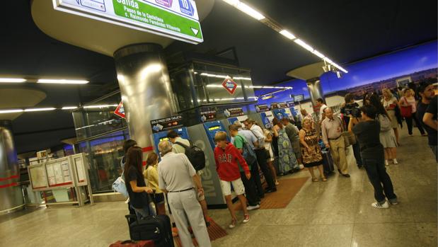 Viajeros en las máquinas expendedoras de billetes en el Metro de Madrid