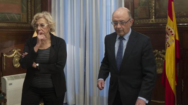 La alcaldesa de Madrid, Manuela Carmena, y el ministro de Hacienda, Cristóbal Montoro, durante una reunión