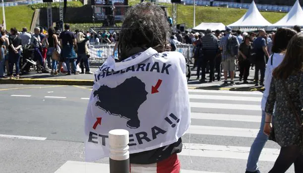 Una personas se cubre con una bandera a favor del acercamiento de los presos de ETA, en Bayona