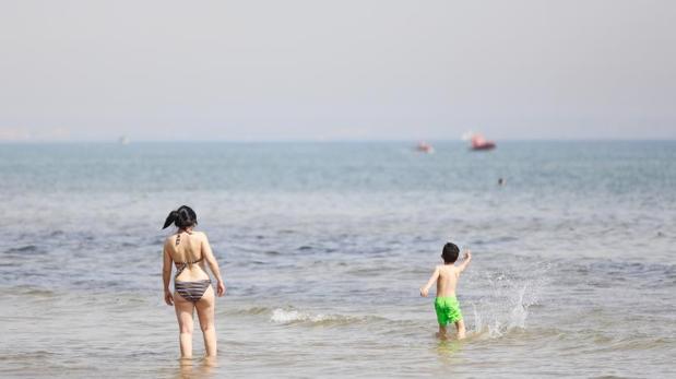 Dos bañistas en la playa de València, este Viernes Santo