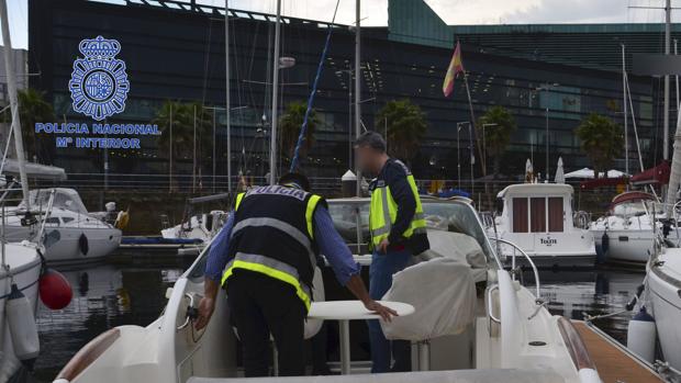 Agentes de la Policía Nacional inspeccionan la embarcación del detenido