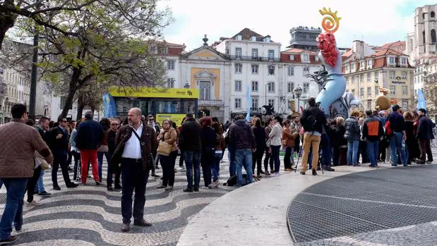 Público visitando la hoguera alicantina y la oficina de información turística en Lisboa