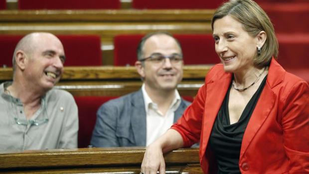 Forcadell, en primer plano, y Llach y Turull, sentados en el Parlamento de Cataluña