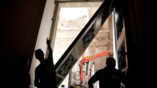 Imagen de los operarios en los trabajos para reponer la puerta de la Basílica