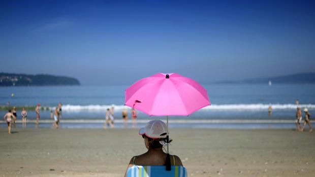 Varias personas disfrutando del buen tiempo en la playa en La Coruña