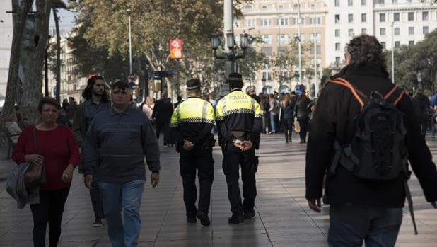 Dos agentes de la Guardia Urbana patrullan por el centro de Barcelona