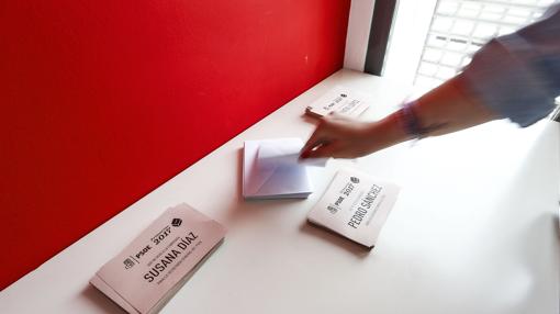 Una joven coge un sobre para votar en el proceso de primarias del PSOE, este mediodía en la sede del PSPV-PSOE de Valencia