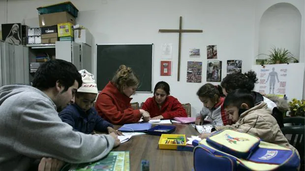 Voluntarios dando clase a varios niños en el poblado del Gallinero, en Madrid