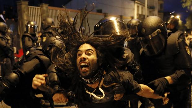 La policía desaloja a un manifestante del interior de un inmueble tras la manifestación por laP calles de Santiago