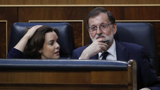 El presdiente del Gobierno Mariano Rajoy (dcha) junto a Soraya Sáenz de Santamaría en el Congreso
