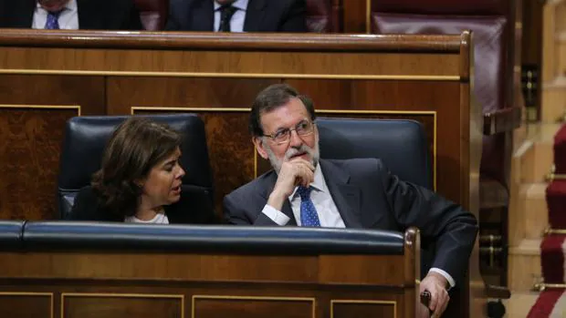 El presidente del Gobierno, Mariano Rajoy, conversa con la vicepresidenta en el Congreso