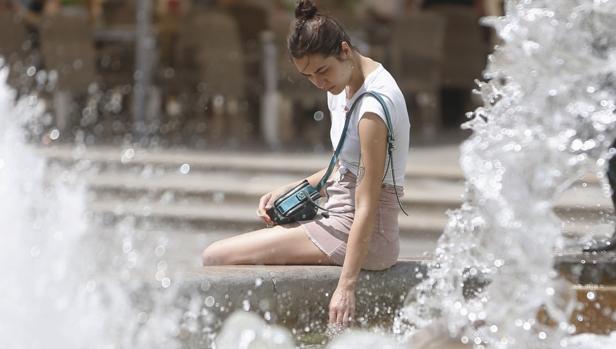 Una joven se refresca en una fuente, este martes en Valencia