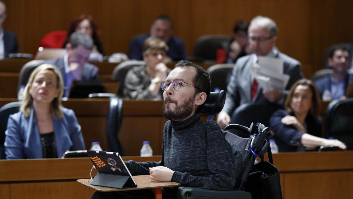 Pablo Echenique, líder regional de Podemos y número 3 del partido a nivel nacional, pasa ante la bancada socialista durante un pleno de las Cortes de Aragón