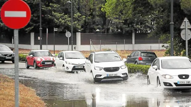 Varios coches circulan ayer por una calle inundada en Boadilla del Monte tras la tormenta