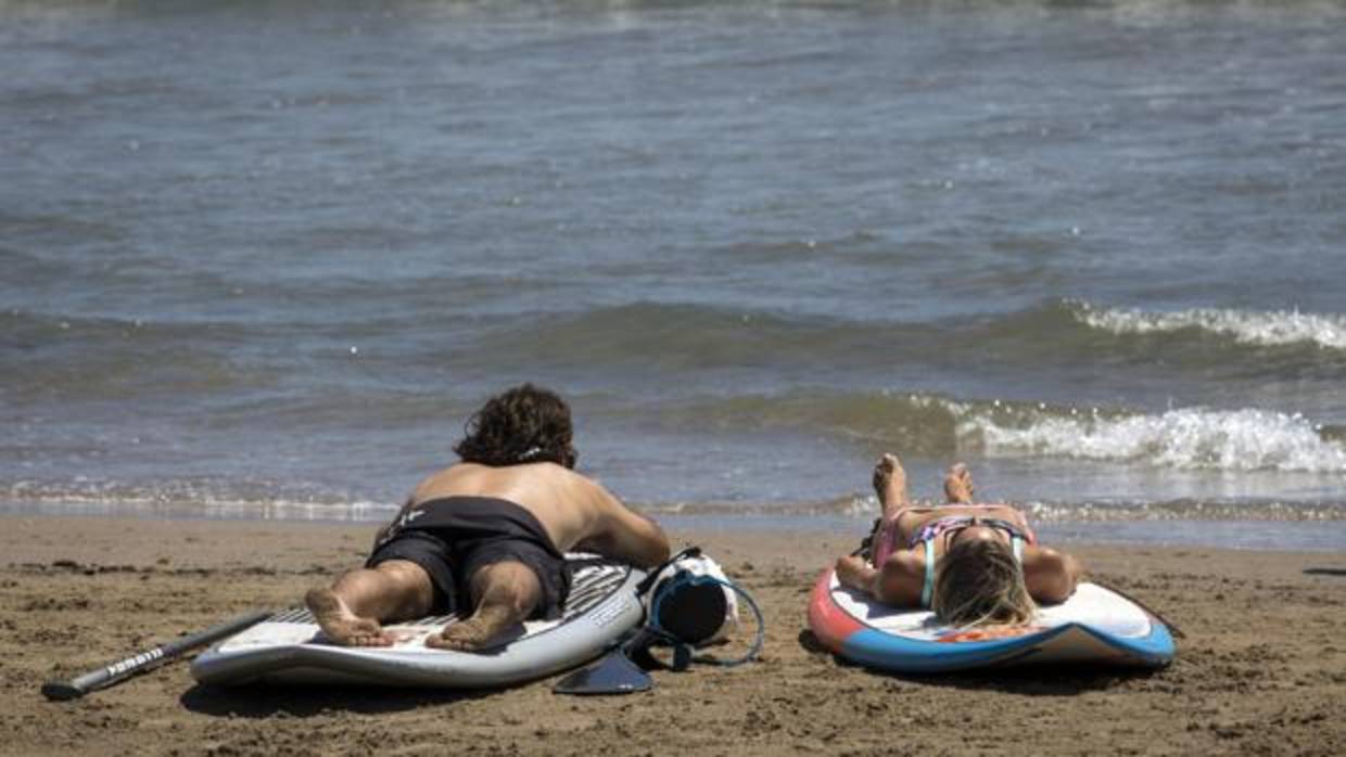 Imagen de dos bañistas en la playa de Las Arenas de Valencia