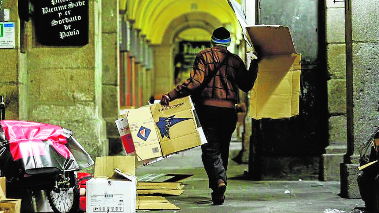 Un «sin techo» prepara los cartones para dormir en la Plaza Mayor