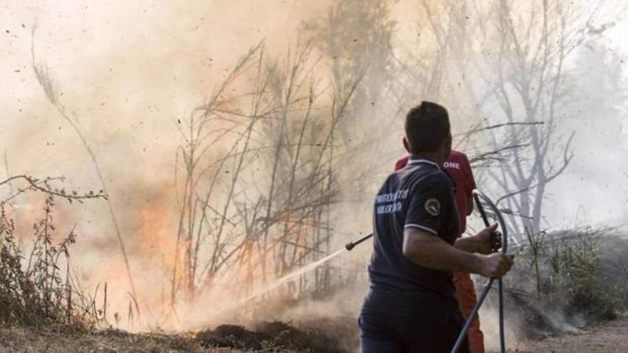 Un helicóptero trabaja en las labores de extinción del incendio producido ayer por la tarde en la sierra de Arroyo de Serván (Badajoz)
