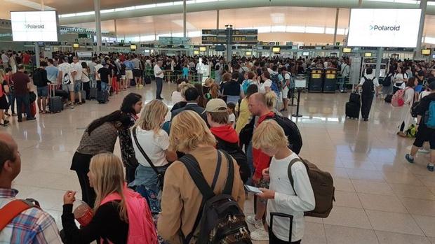 Viajeros esperando pasar los controles del aereopuerto de Barcelona-El Prat