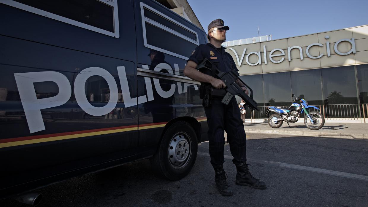 Imagen de archivo de un agente y un coche de la Policía Nacional de Valencia