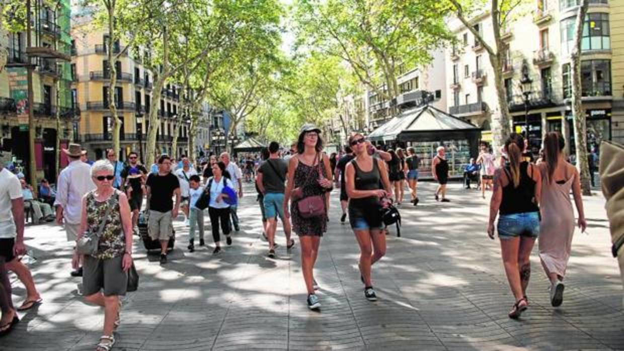 Turistas y barceloneses paseando ayer por las Ramblas
