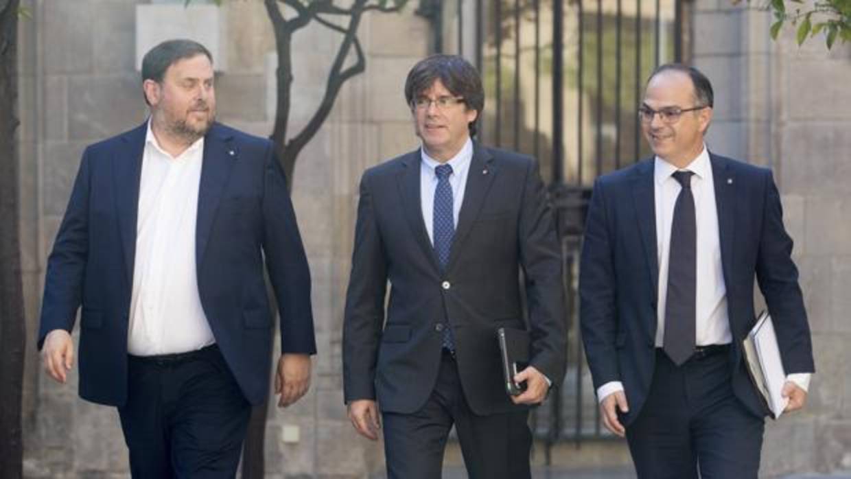 Carles Puigdemont, junto al vicepresidente y conseller de Economía, Oriol Junqueras, y el conseller de la Presidencia, Jordi Turull