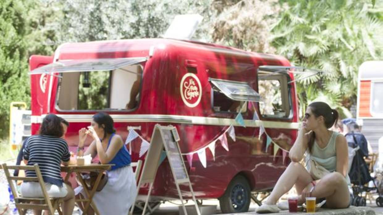 Varios jóvenes comiendo en la terraza de una foodtruck