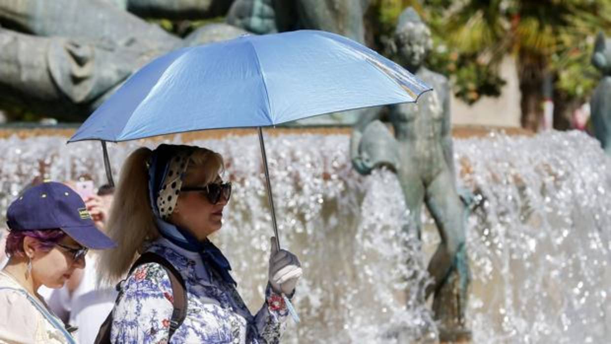 Imagen de una mujer protegiéndose del calor tomada este jueves en el centro de Valencia