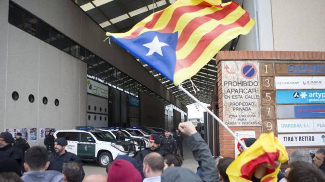 Simpatizantes independentistas protestan ante los agentes de la Guardia Civil, en la imprenta Artyplan de Sant Feliu de Llobregat