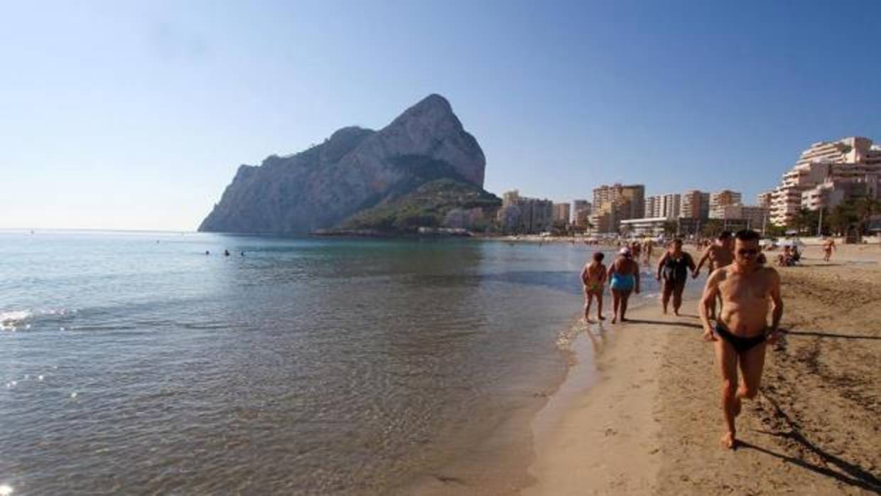 Bañistas en la playa junto al Pelón de Ifach, en Calpe