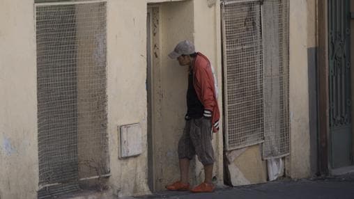 Un hombre de origen asiático espera para entrar en un bloque «okupado»