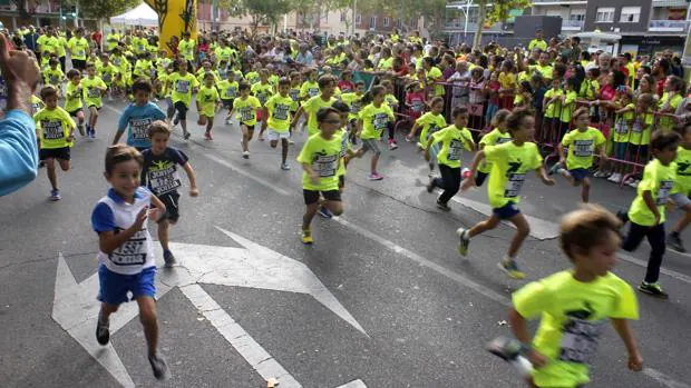 Decenas de niños toledanos corren tras salir de la meta en la calle Méjico