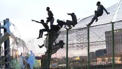 Algunos inmigrantes saltando la valla de Melilla
