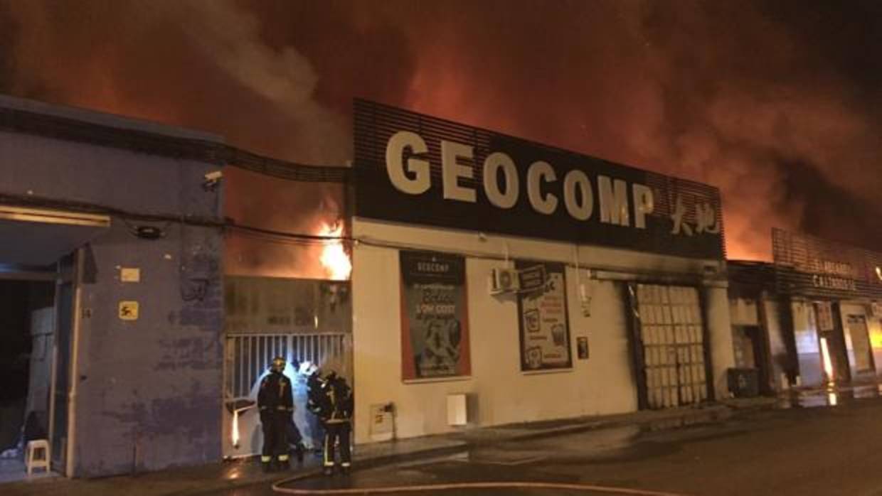 Los bomberos tratan de apagar las llamas, en el polígono de Cobo Calleja
