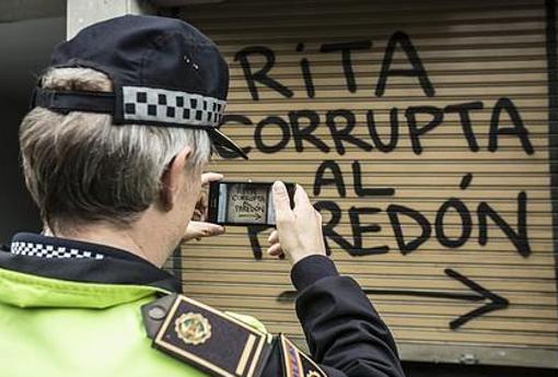 Un policía toma imágenes de la pintada contra Rita Barberá