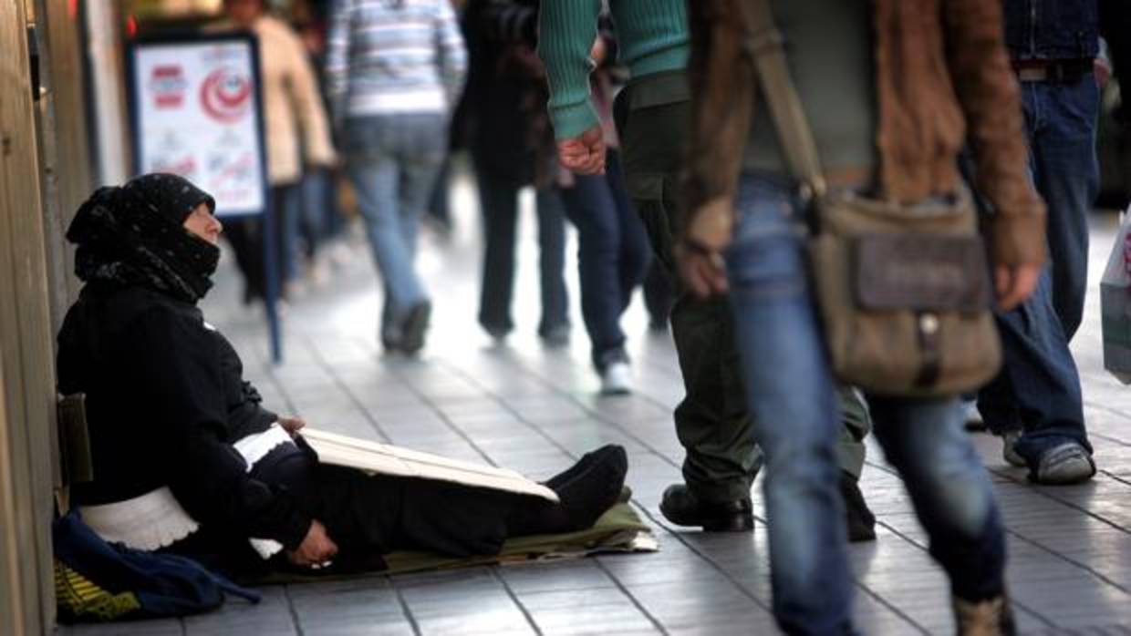 Una mujer pide limosna en una calle del centro de Valencia