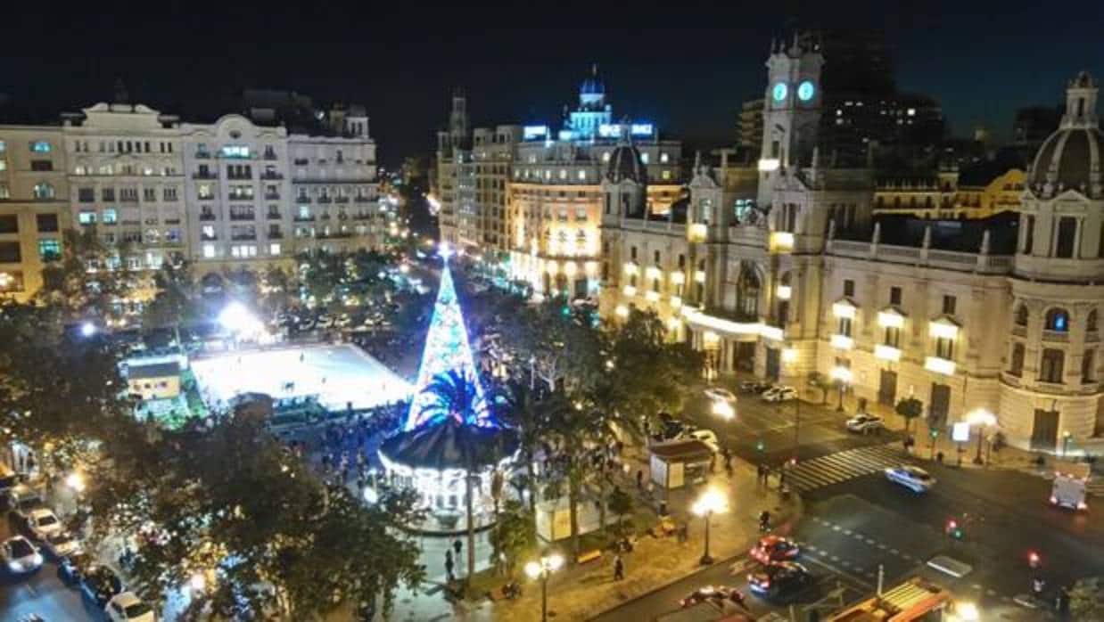 La plaza del Ayuntamiento de Valencia, iluminada con luces de Navidad y con la pista de hielo