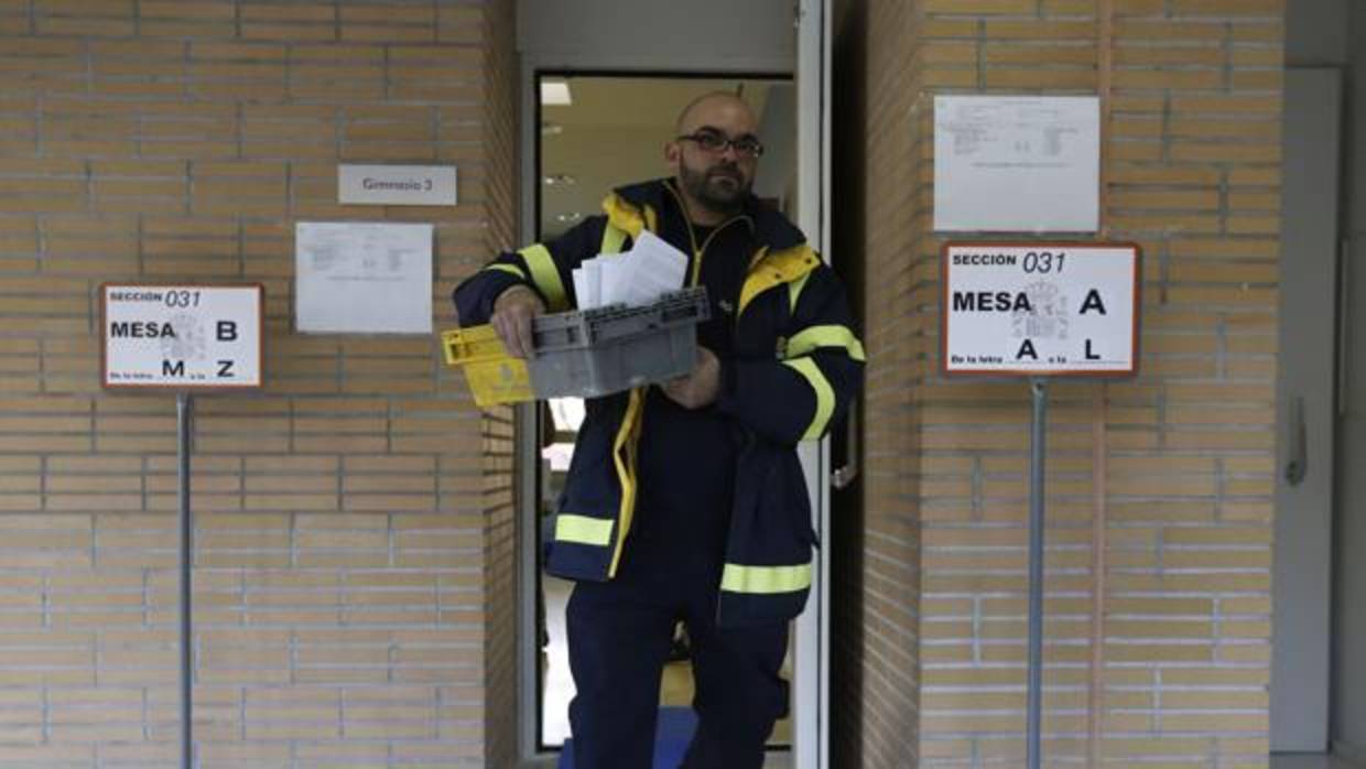 Un empleado lleva el voto por correo a un colegio electoral el 20-D de 2016