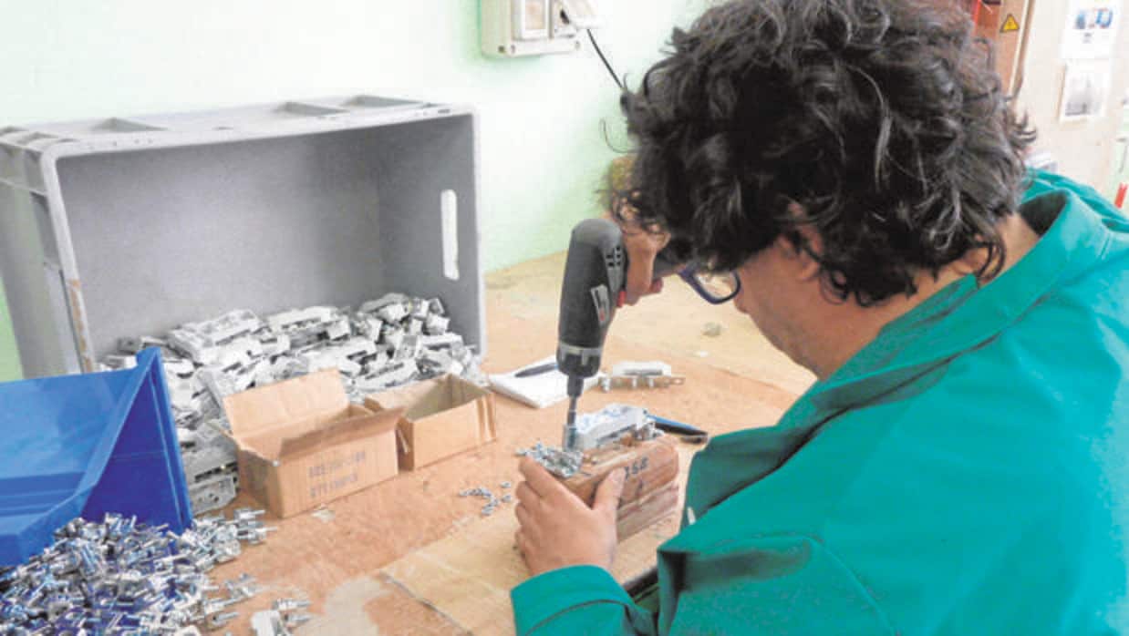 Un hombre trabaja en un taller de piezas de un Centro especial catalán